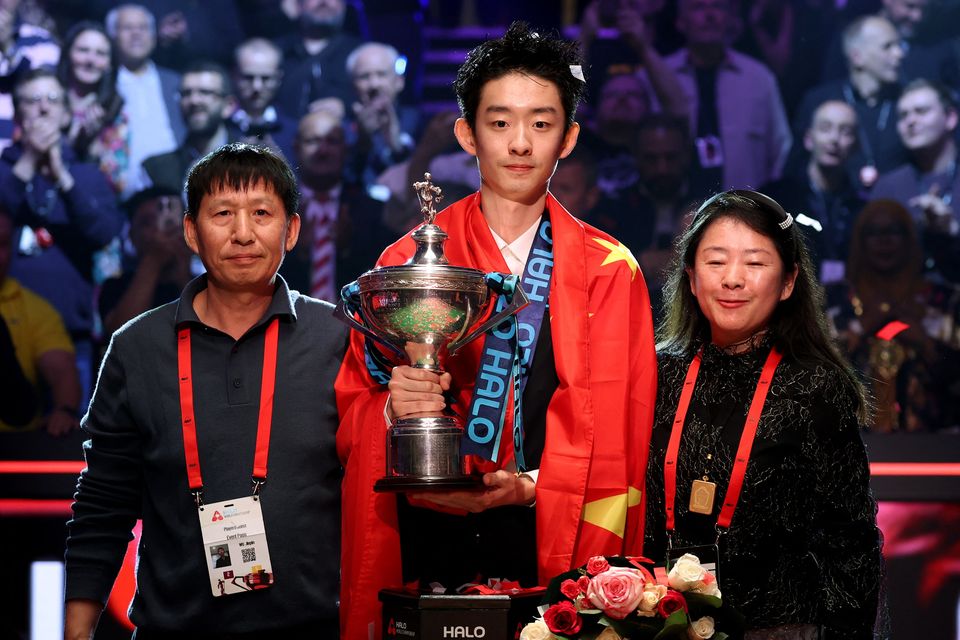 China's Wu Yize poses with the World Snooker Championship trophy alongside his parents after winning his final match against England's Shaun Murphy at The Crucible Theatre, Sheffield. Photo: Action Images via Reuters/Andrew Boyers